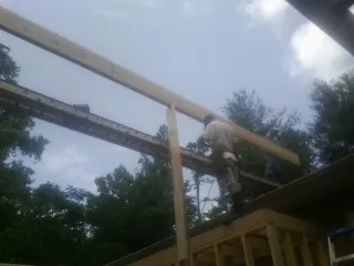 Carpenter setting a ridge beam over a new addition frame — Ice Dam Removal by Roofing Brothers in Albuquerque