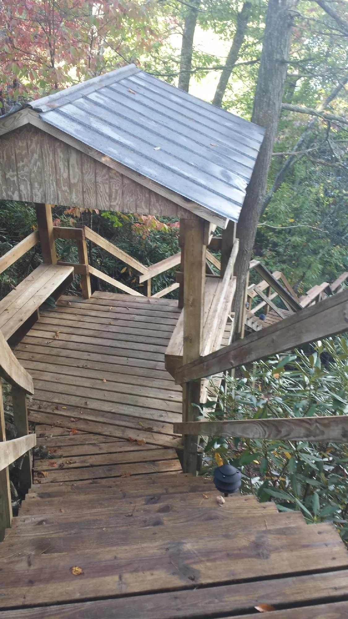 Metal roofed shelter over wooden steps on a wooded walkway — Skylight Repair & Installation work by our crew in Albuquerque